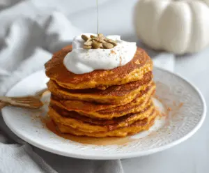 Delicious pumpkin cottage cheese pancakes topped with fresh berries and a drizzle of maple syrup, perfect for a cozy breakfast.