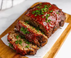 Delicious homemade air fryer meatloaf served on a plate with vegetables, showcasing a juicy, flavorful, and perfectly cooked meal