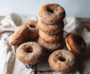 Delicious cinnamon apple donuts with a golden-brown exterior and a sprinkle of cinnamon on top.