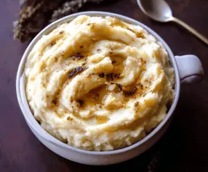 Creamy roasted garlic mashed potatoes served in a rustic bowl, perfect for a comforting side dish.