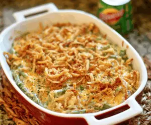 Delicious green bean casserole topped with crispy potatoes, served in a white baking dish for a flavorful side dish.