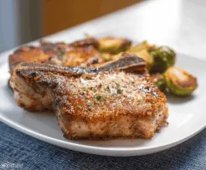 Juicy Air Fryer Pork Chops served with fresh herbs on a rustic plate