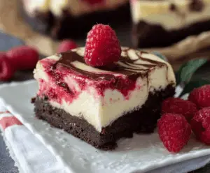 Delicious Raspberry Brownie Cheesecake with a rich chocolate crust, fresh raspberries, and creamy cheesecake topping.