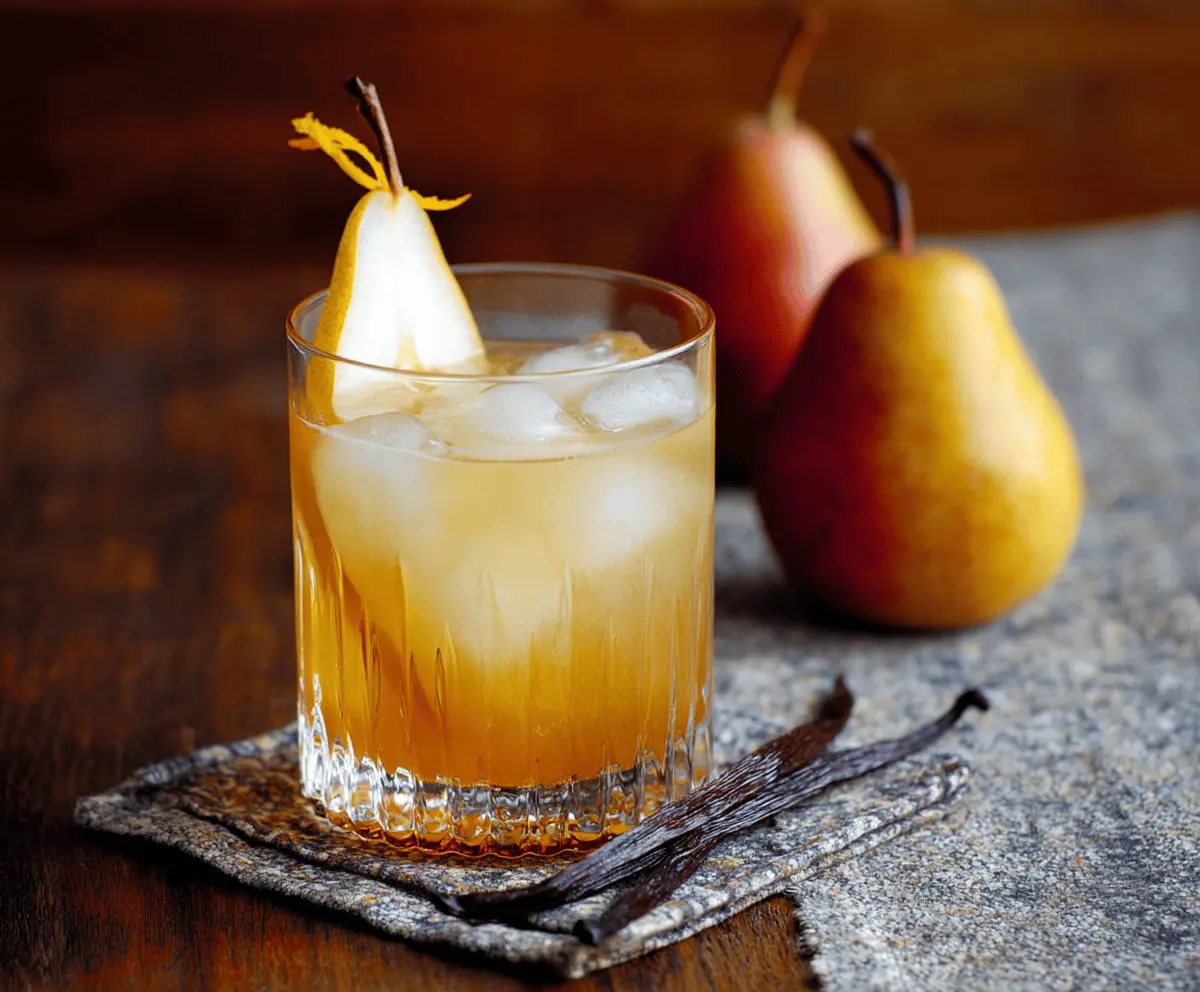 Delicious Vanilla Pear Bourbon Cocktail in a tall glass with garnished pear and vanilla pod, perfect for elegant evenings.