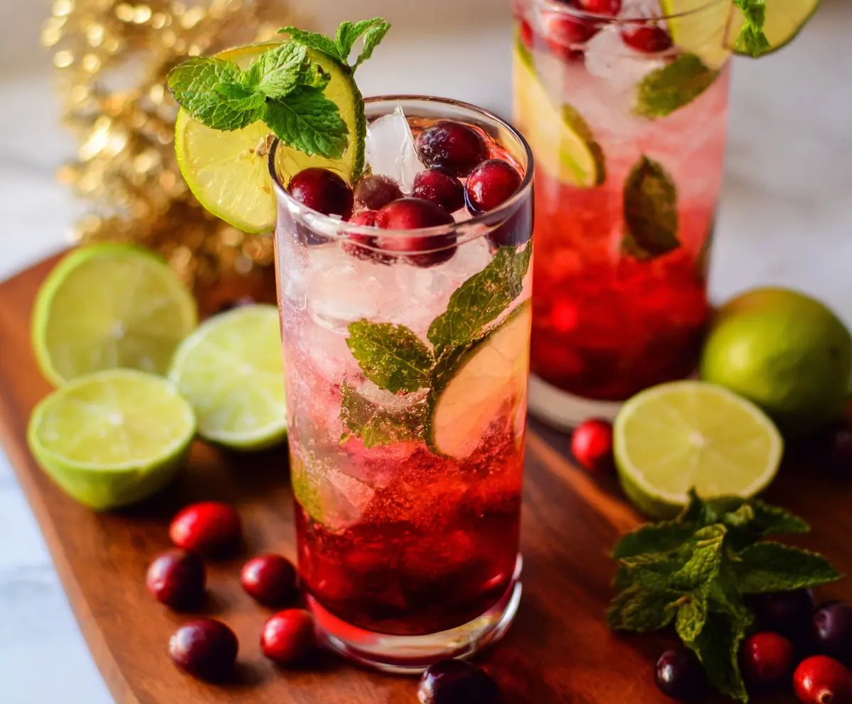 Refreshing Cranberry Mint Mojito in a tall glass garnished with fresh mint and cranberries
