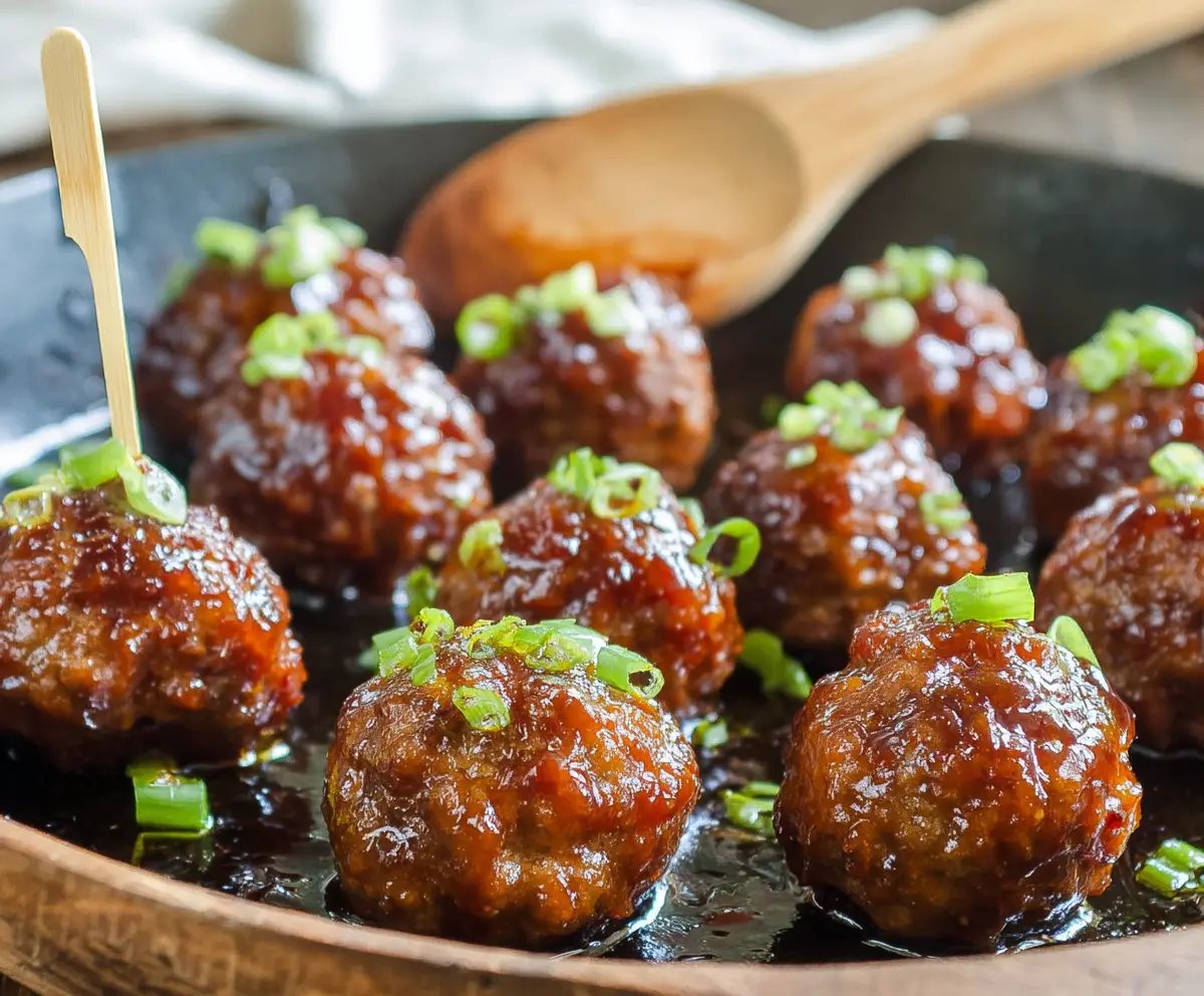 Savory Honey Sriracha Meatballs served on a platter with fresh herbs