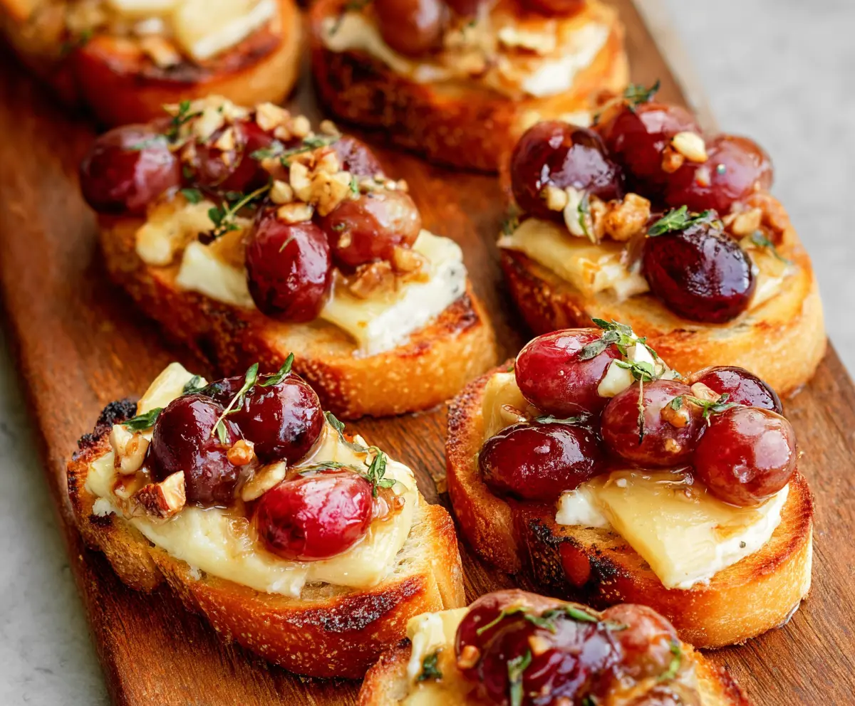 Delicious roasted grape and Brie crostini with melted cheese and caramelized grapes on toasted baguette slices.