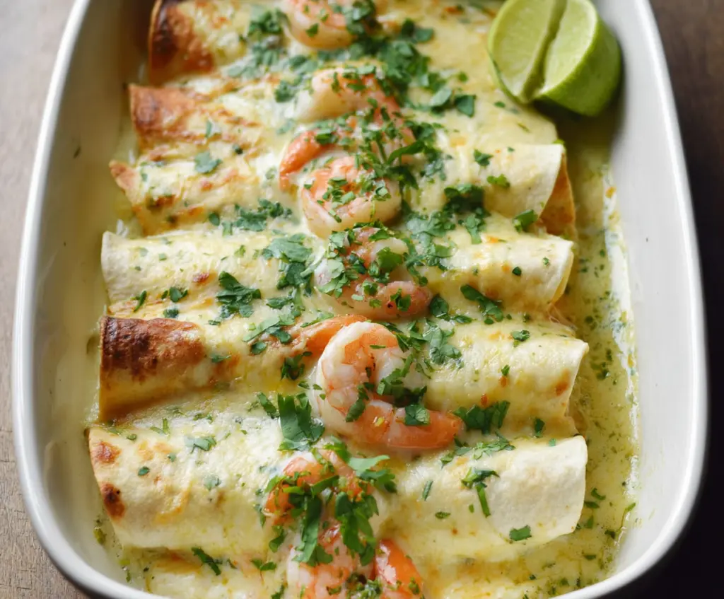 Delicious shrimp enchiladas topped with creamy poblano sauce garnished with fresh cilantro.