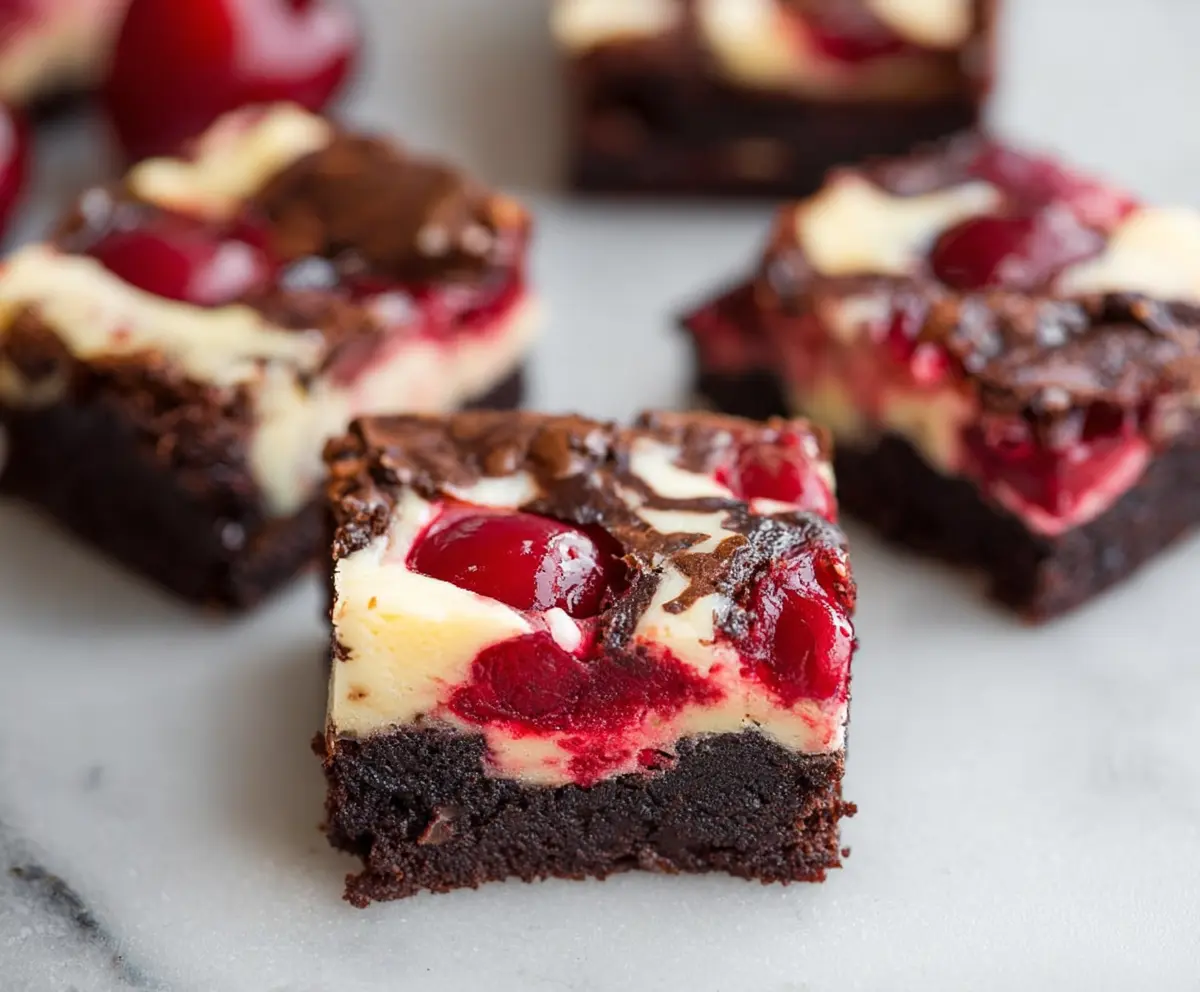 Delicious cherry cheesecake brownies with a rich chocolate base and swirls of cherry topping.