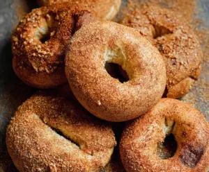 Freshly baked cinnamon bagels with a golden crust and a sprinkle of cinnamon on top.