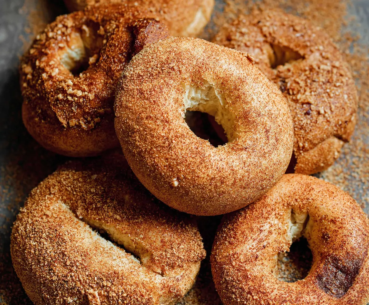 Freshly baked cinnamon bagels with a golden crust and a sprinkle of cinnamon on top.