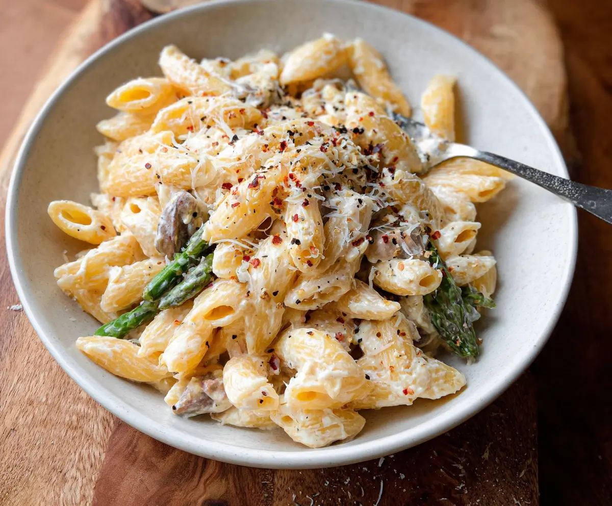 Creamy ricotta pasta served in a white bowl with fresh herbs on top, showcasing a delicious Italian-inspired dish.