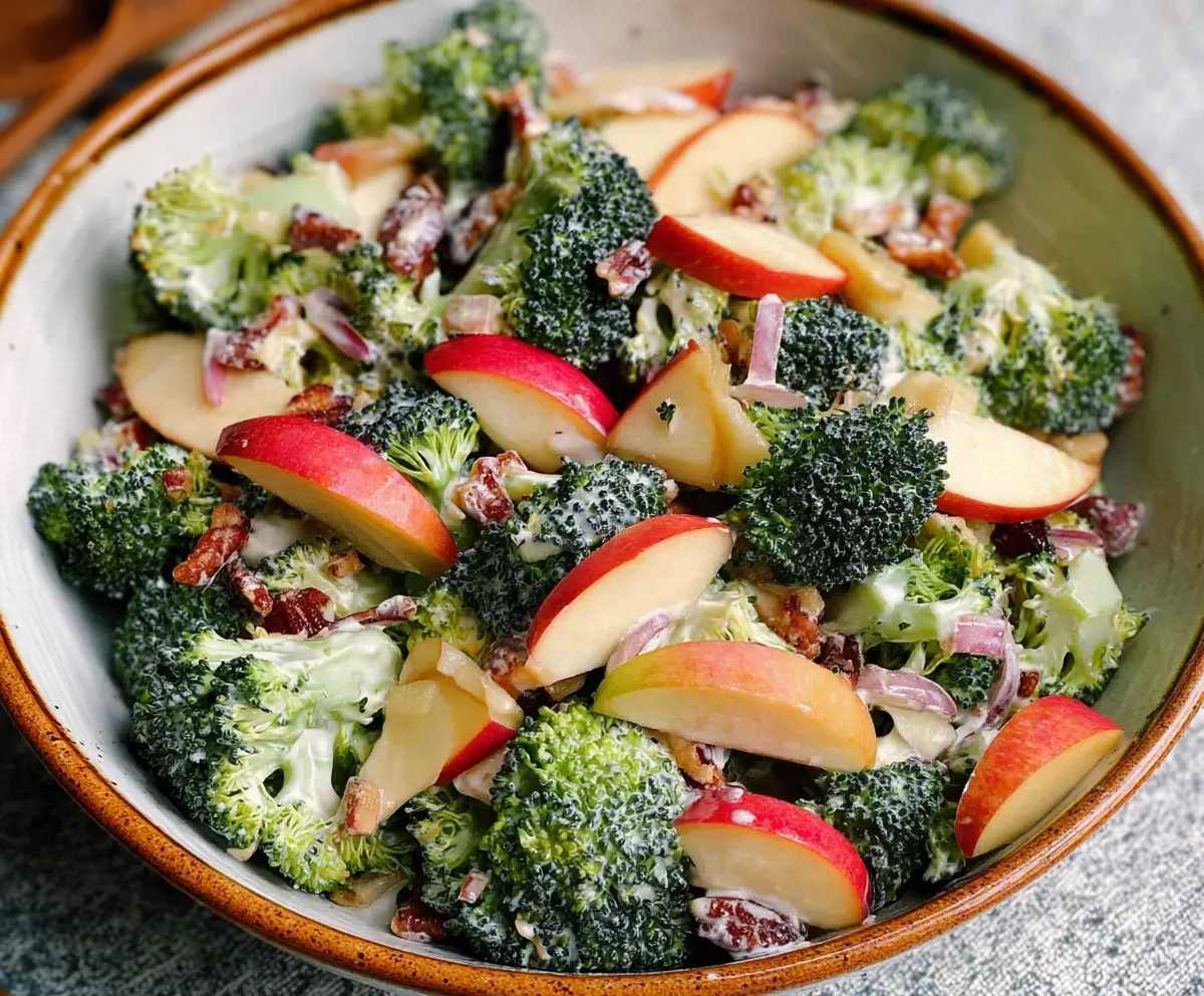 Fresh broccoli and apple salad in a bowl, with vibrant green and red colors, perfect for healthy eating.