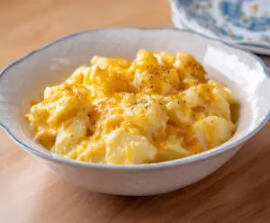 Creamy and cheesy crockpot potatoes garnished with herbs, perfect for a comforting meal.