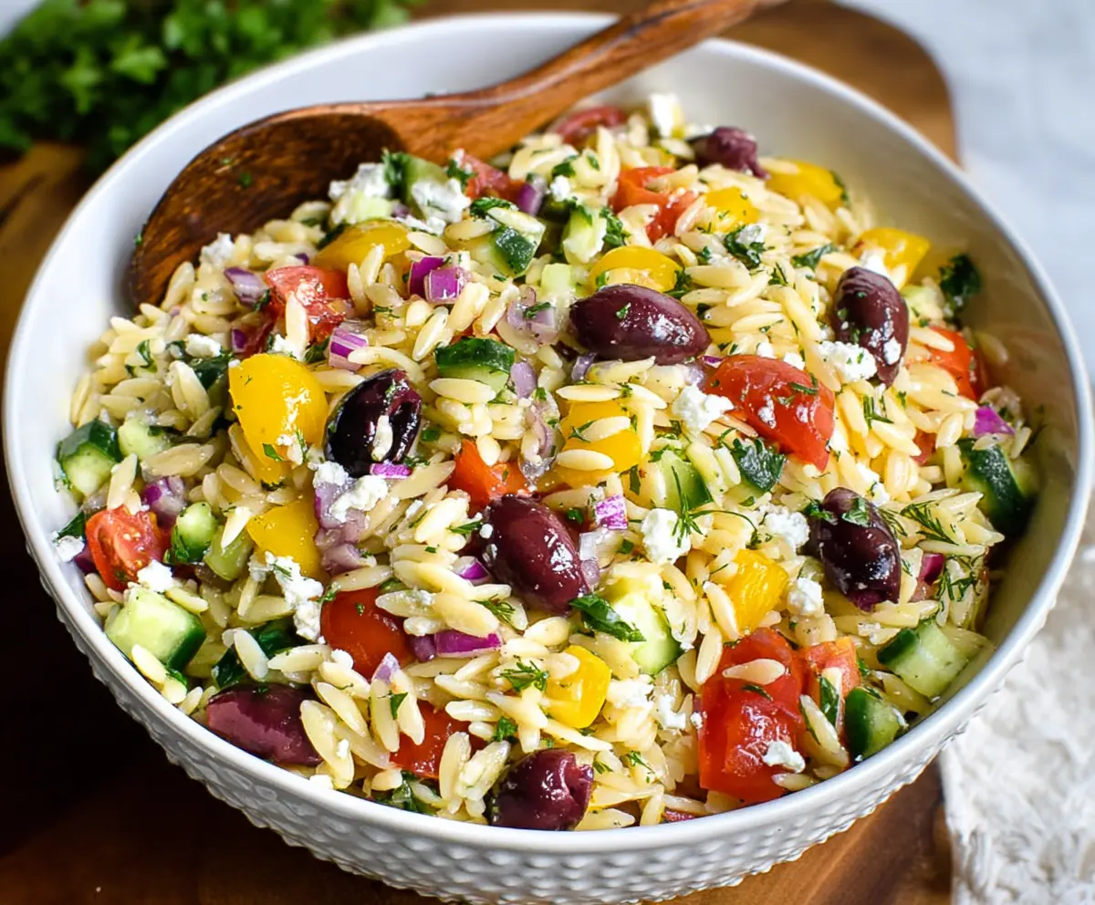 Bright Greek Orzo Salad with fresh vegetables and feta cheese, perfect for summer picnics.